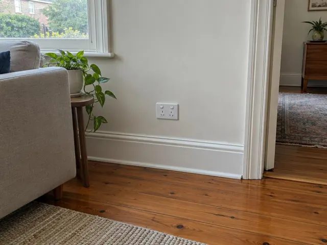 Double power point on a plaster wall above timber flooring in a living room in Bellevue Hill